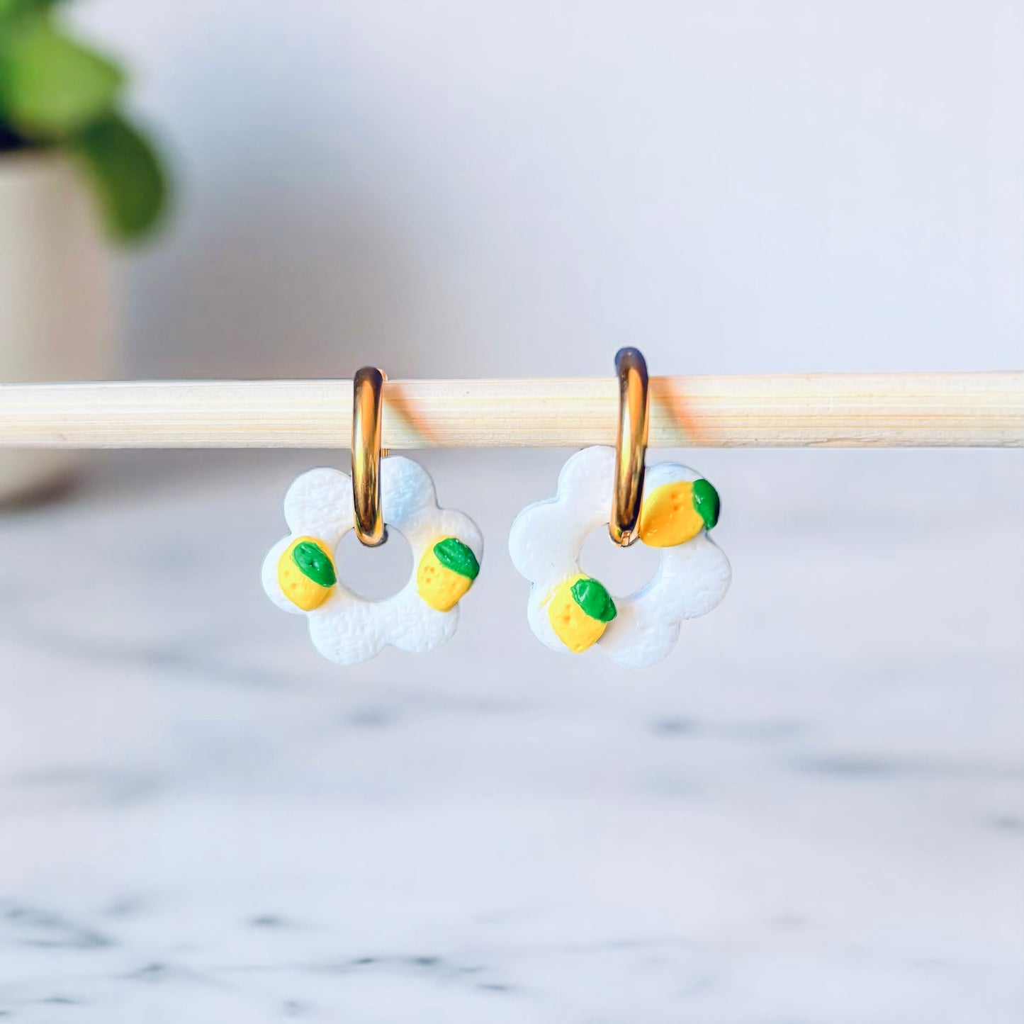 Photo d'une paire de boucles d'oreille créoles fleur citron plaquée or
