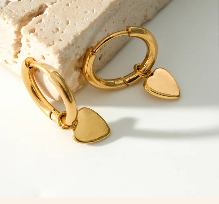 une paire de boucles d'oreilles créoles plaquées or avec petit coeur mignon