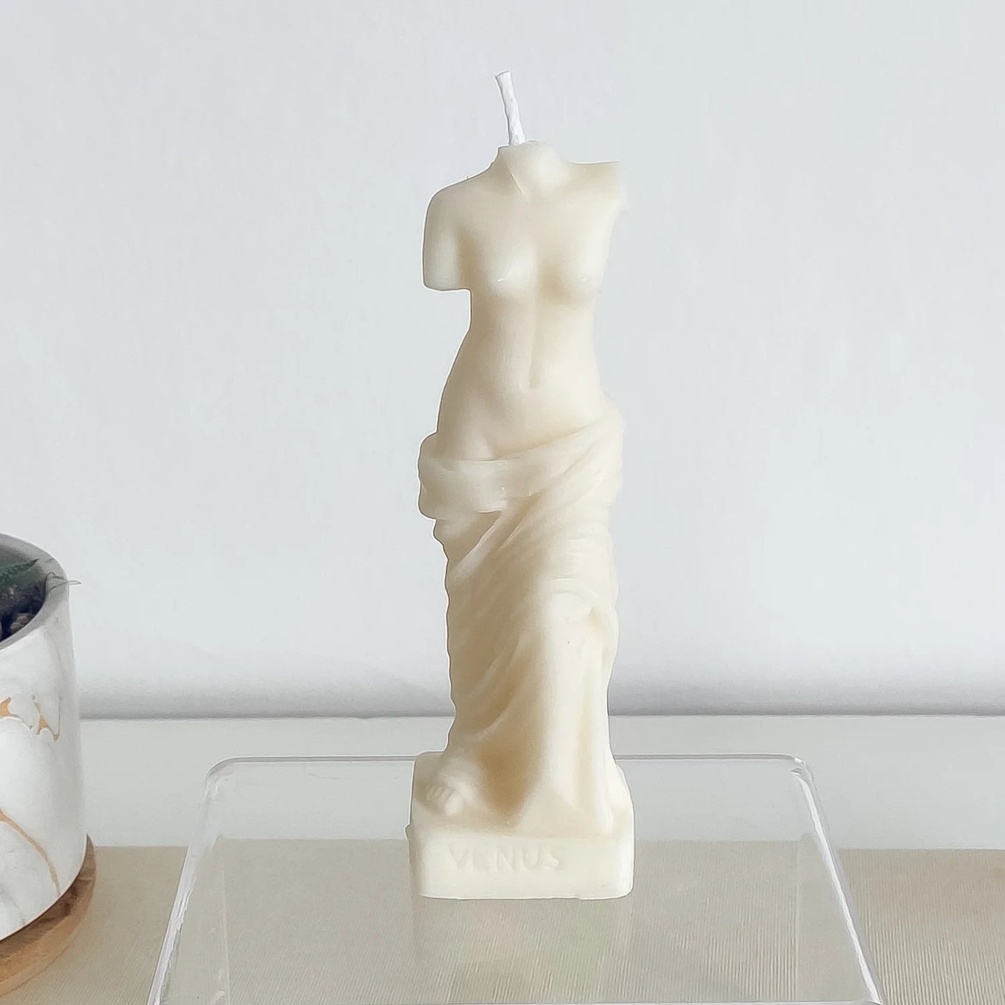 Une bougie blanche en forme de buste de femme