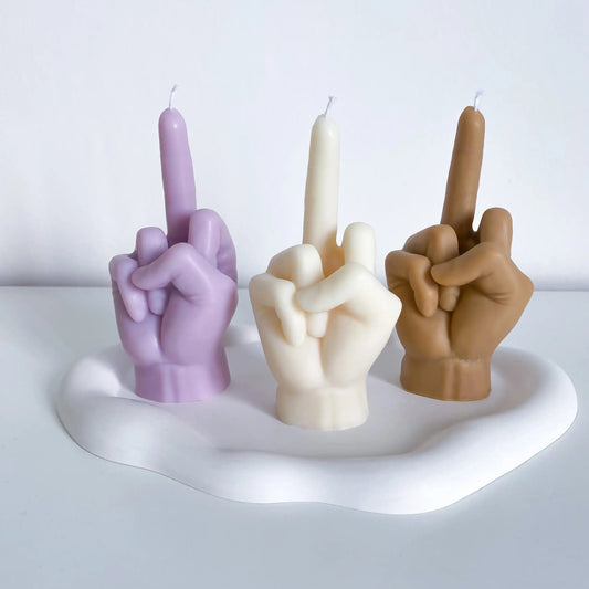 une bougie fuck violette, une bougie fuck blanche et une bougie fuck marron