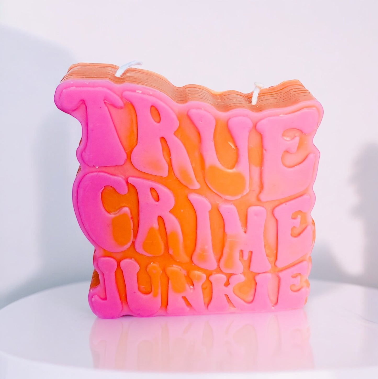 Photo d'une bougie true crime junkie rose et rouge