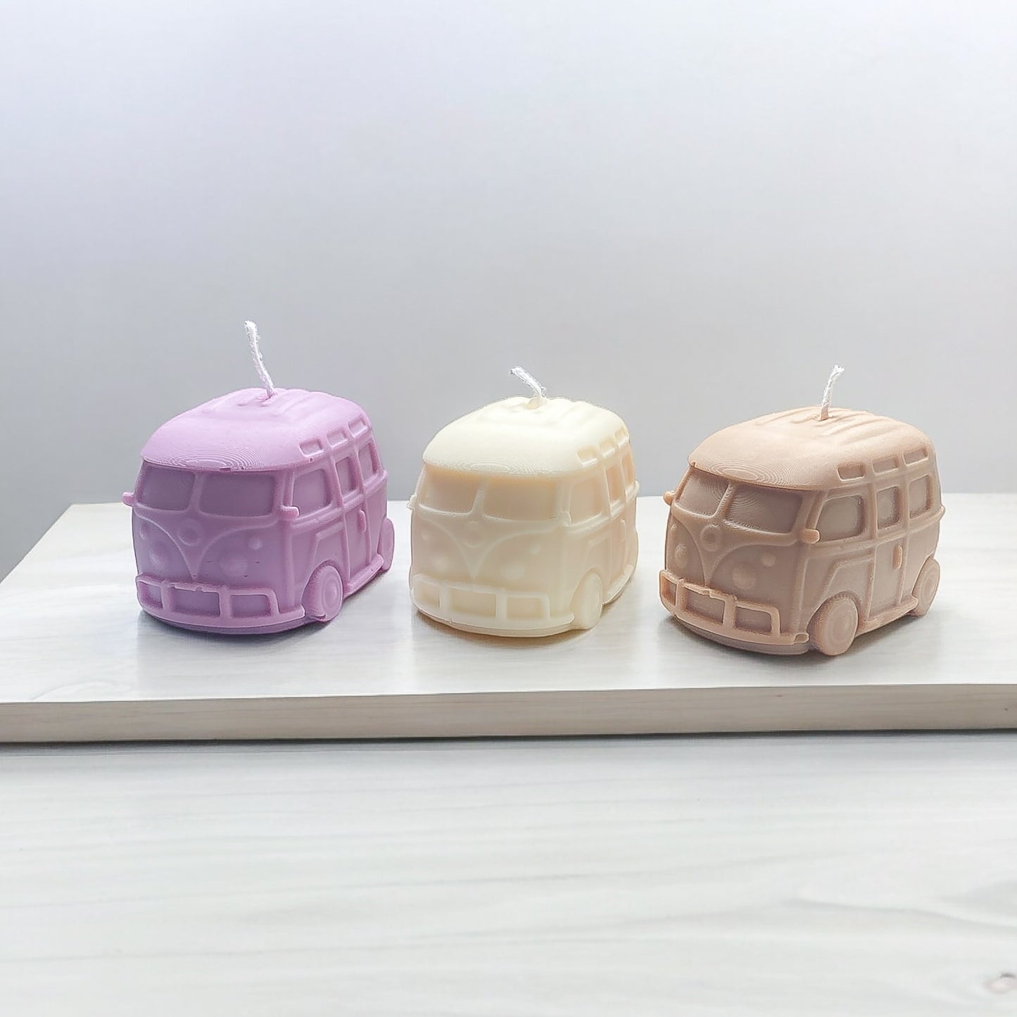 Une bougie van violette, une bougie van blanche et une bougie van marron