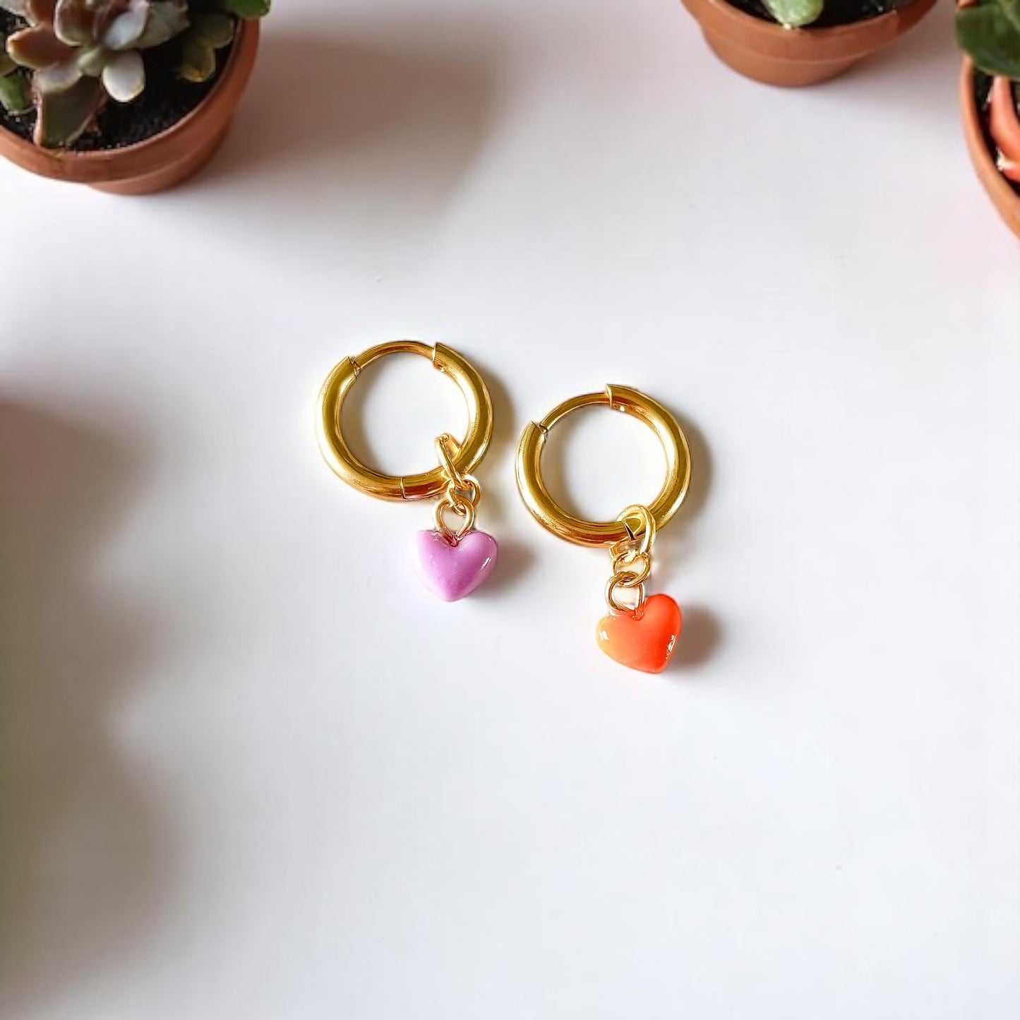 Des charms coeur rose et orange sur des boucles d'oreilles en acier inoxydable et plaquées or