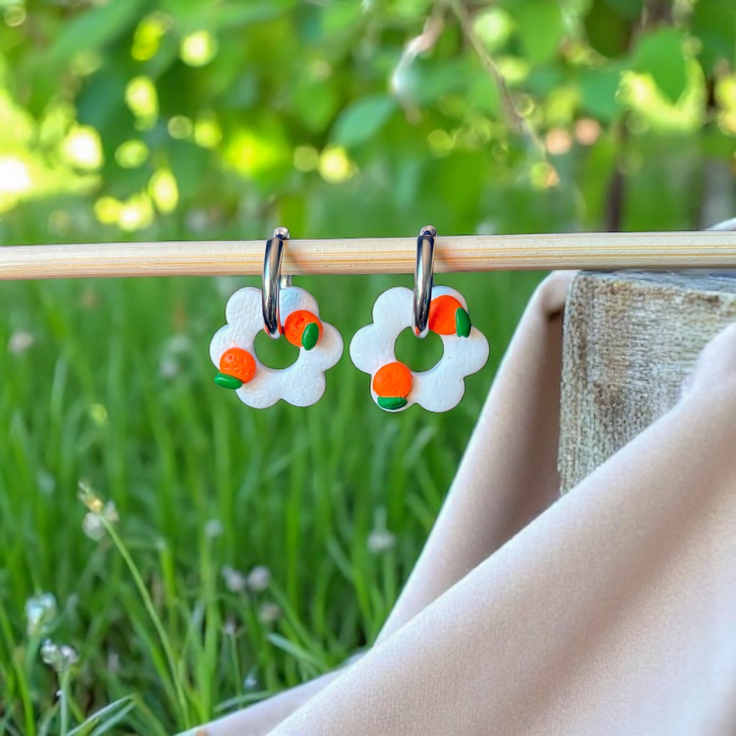 Boucles d'oreilles créoles en forme de fleurs avec des motifs oranges