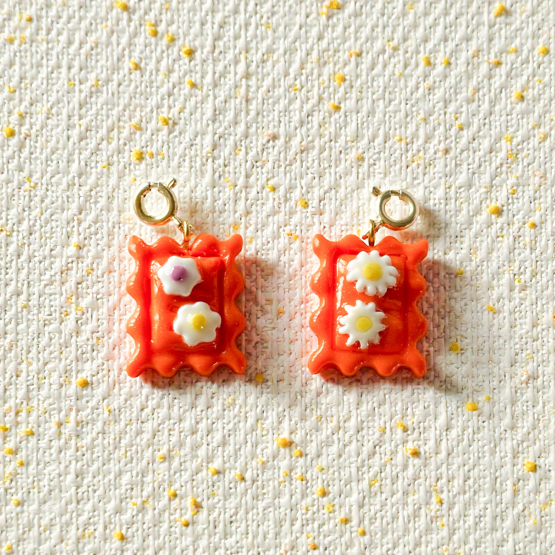 Charm timbre orange avec fleurs jaunes, fait main en pâte polymère, interchangeable, clip pour collier, bracelet ou chaîne, bijou coloré et modulable.