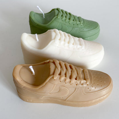 Photo de 3 bougies air force 1 posées côte à côté (marron, blanc, vert)