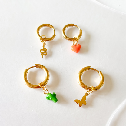 Un assortiment de différents charms (coeur orange, serpent, cactus, papillon)