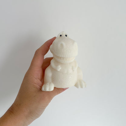 Photo d'une bougie blanche en forme de dinosaure (T-Rex)