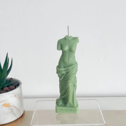 Une bougie verte, sculptée en forme de buste de femme