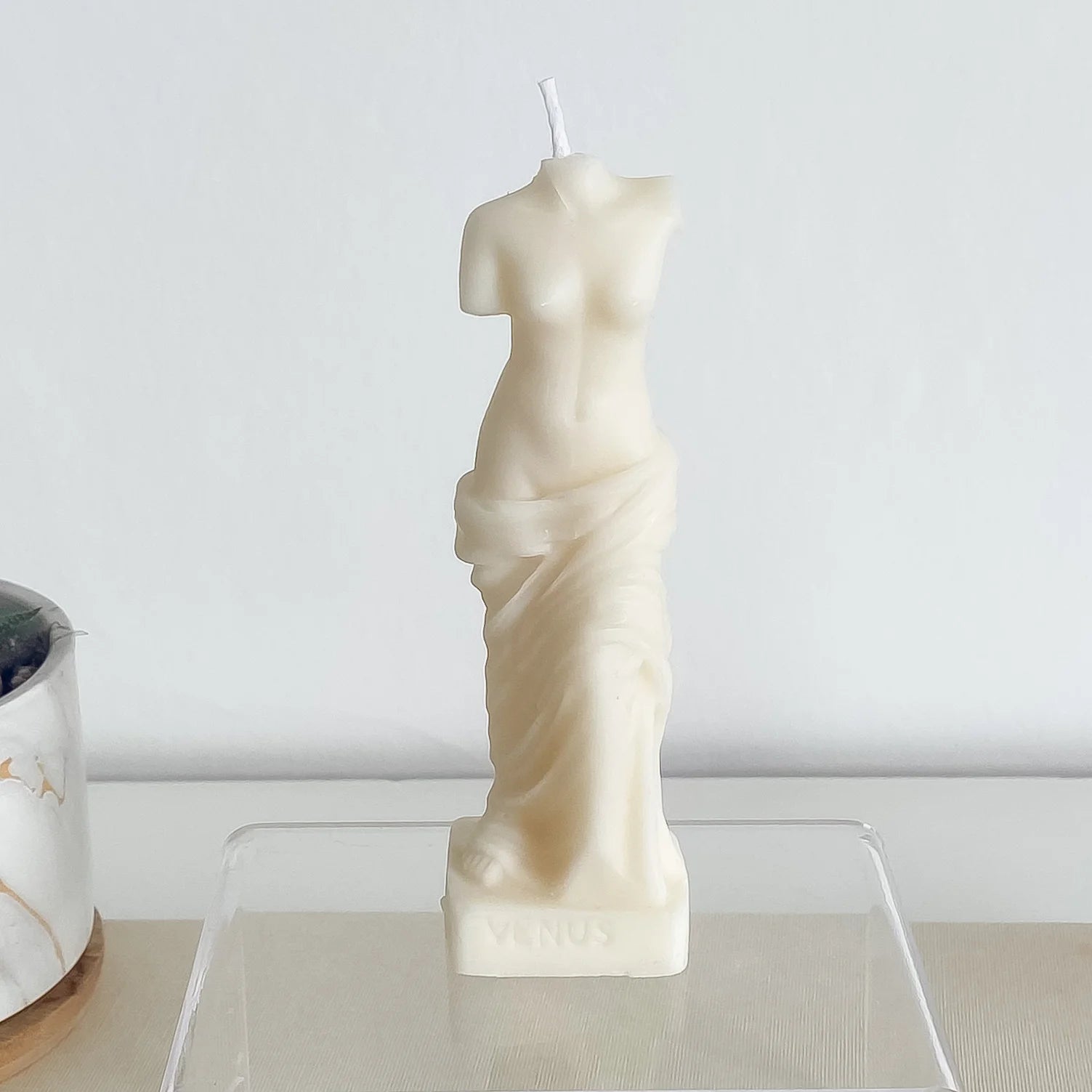Une bougie blanche en forme de buste de femme