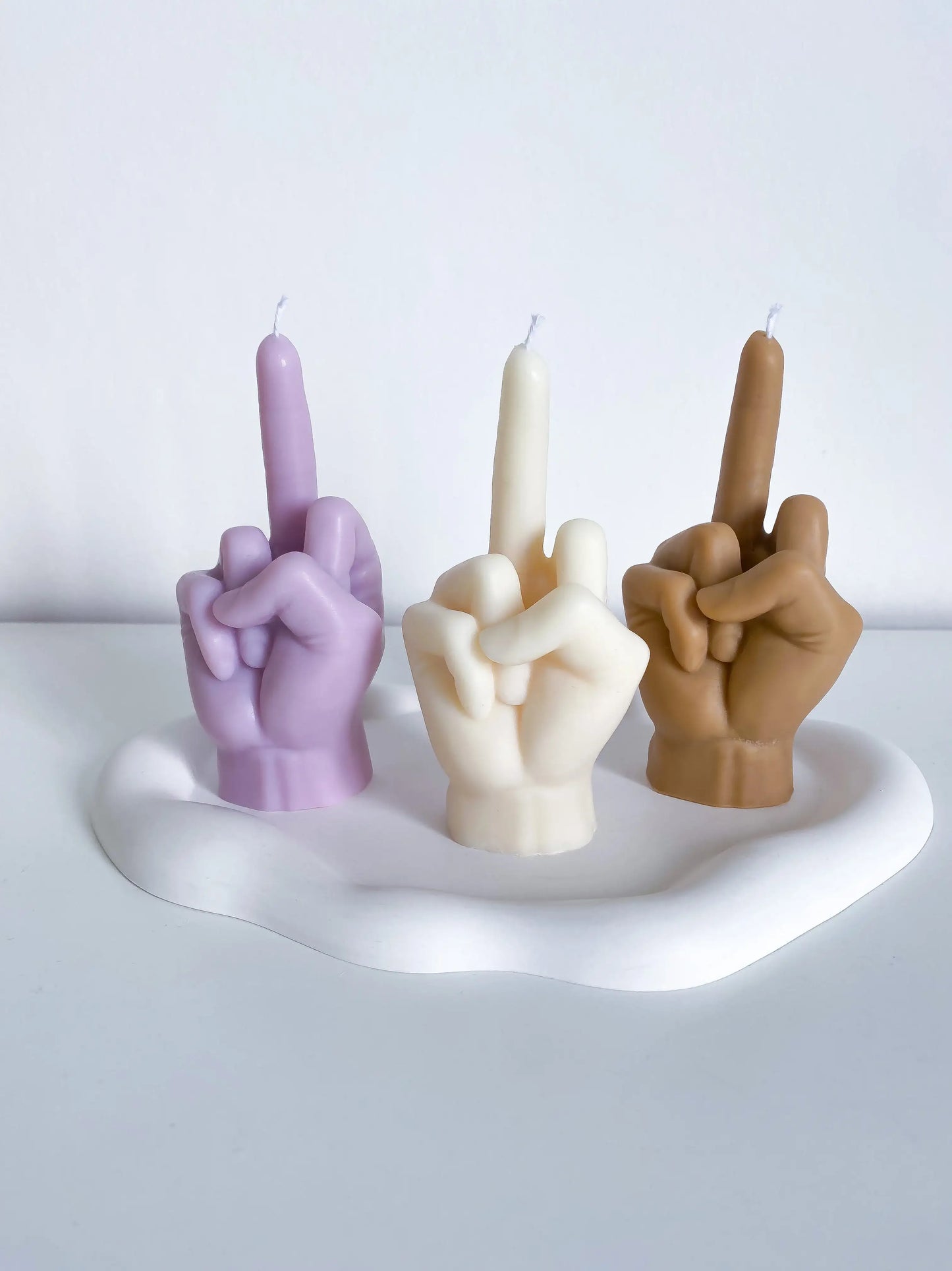 une bougie fuck violette, une bougie fuck blanche et une bougie fuck marron