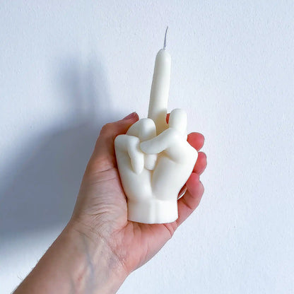 Une bougie fuck blanche, dans la main de la créatrice de la marque Gigi Pop