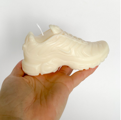 Photo d'une bougie TN Air Max Plus blanche dans la main de sa créatrice