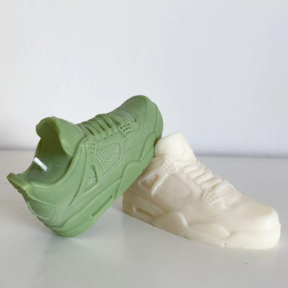 Photo d'une bougie jordan 4 verte posée sur une bougie jordan 4 blanche