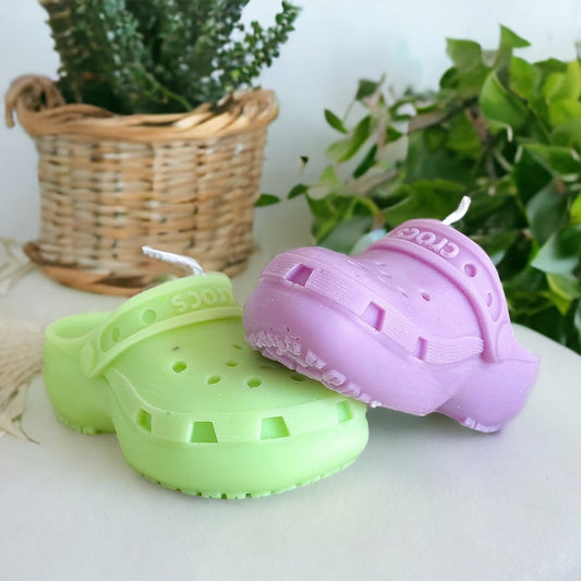 Photo d'une bougie crocs verte et d'une bougie crocs violette posée dessus