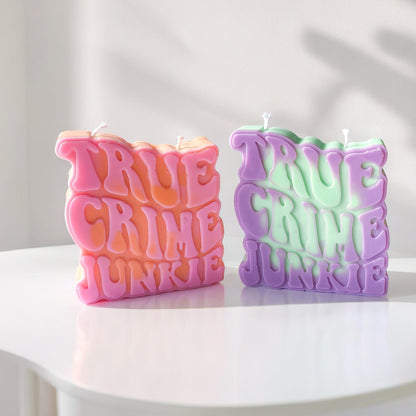 Deux bougies true crime junkie, l'une rose, et l'autre violette