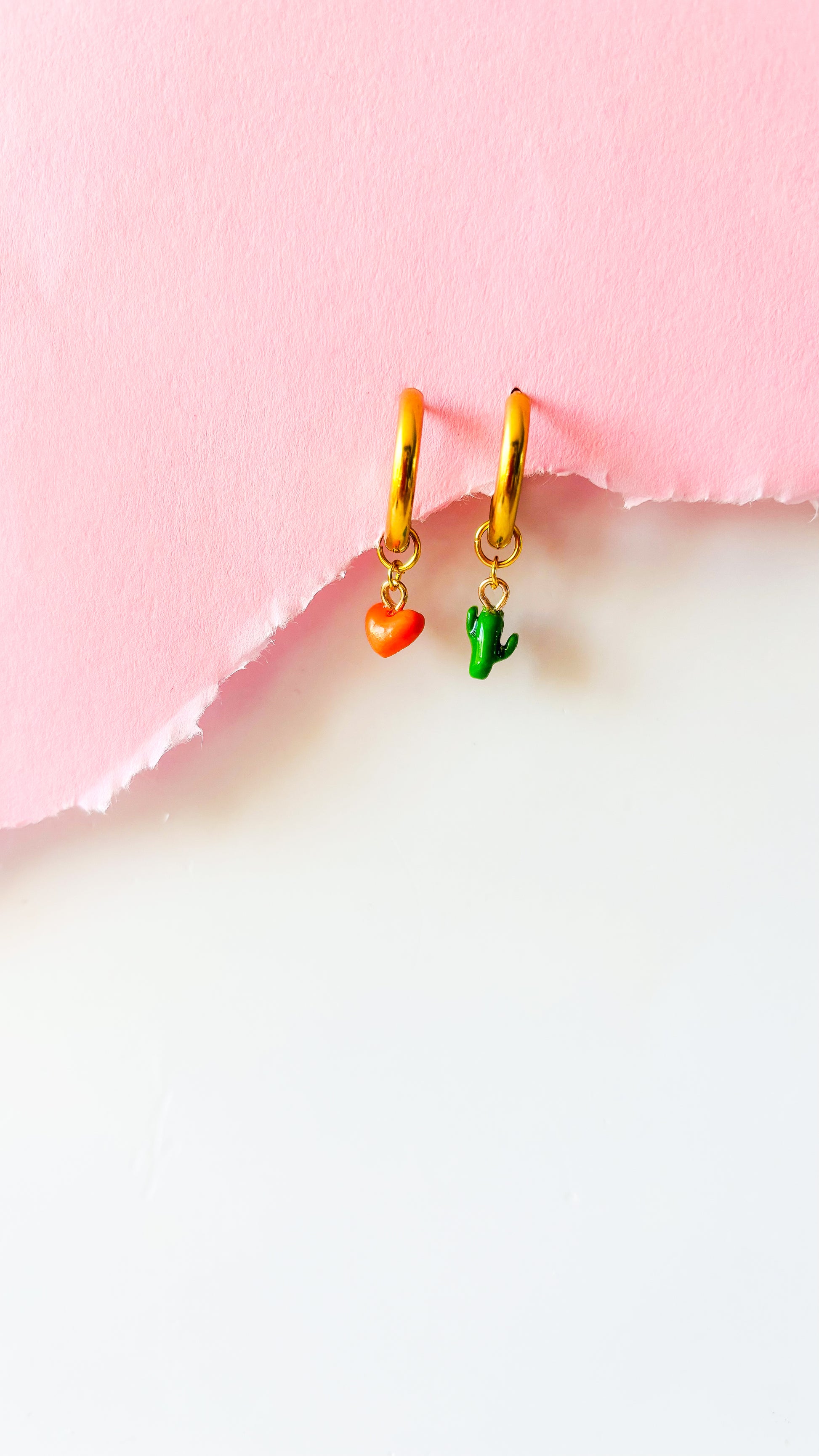 Un charm coeur orange à côté d'un charm cactus