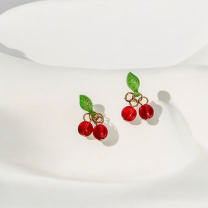 deux charms cerise sur des boucles d'oreille plaquées or en acier inoxydable