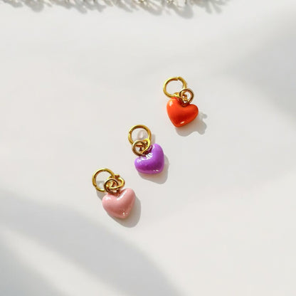 Un lot de 3 charms coeur, l'un rose et les deux autres violet et orange