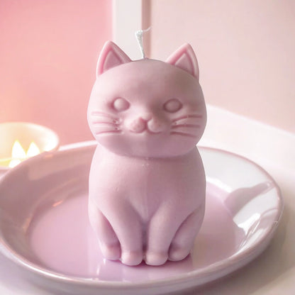 photo d'une bougie chat rose posée dans une assiette de la même couleur