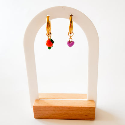 Un charm coeur de couleur violette à côté d'un charm en forme d'orange