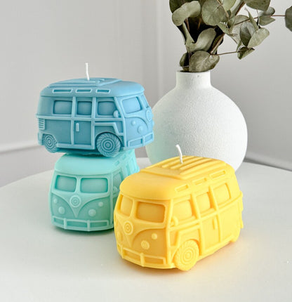 Plusieurs bougies en forme de van, de différentes couleurs (jaune, turquoise, bleu)